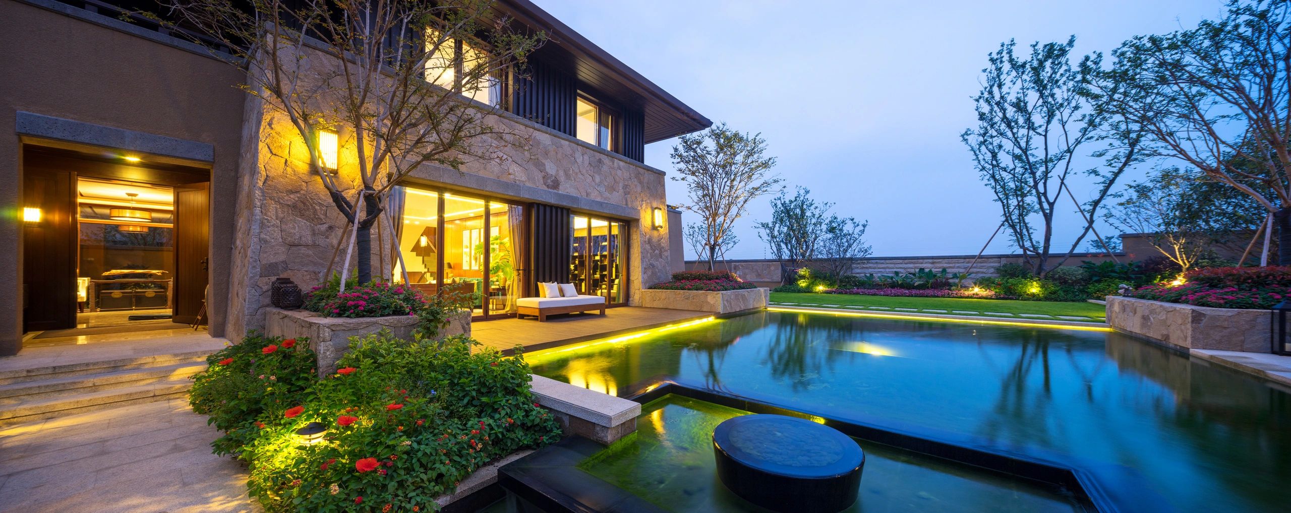 Twilight luxury home with pool exterior lighting